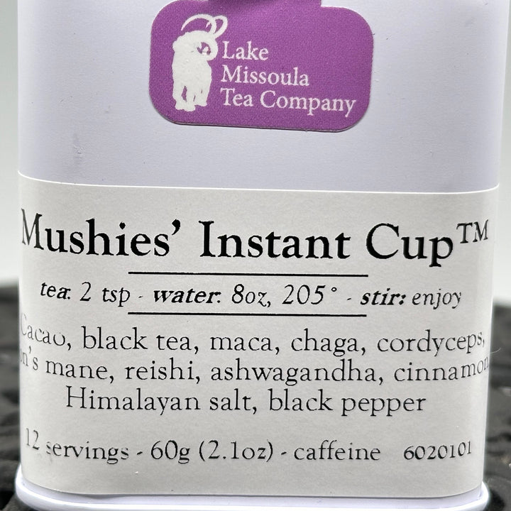 2.1 oz. tin of Lake Missoula Tea Company's Mushies' Instant Cup, Cacao, Black Tea, Maca, Chaga, Cordyceps, Lions Mane, Reishi, Ashwagandha, Cinnamon, Himalayan Salt, Black Pepper, close up
