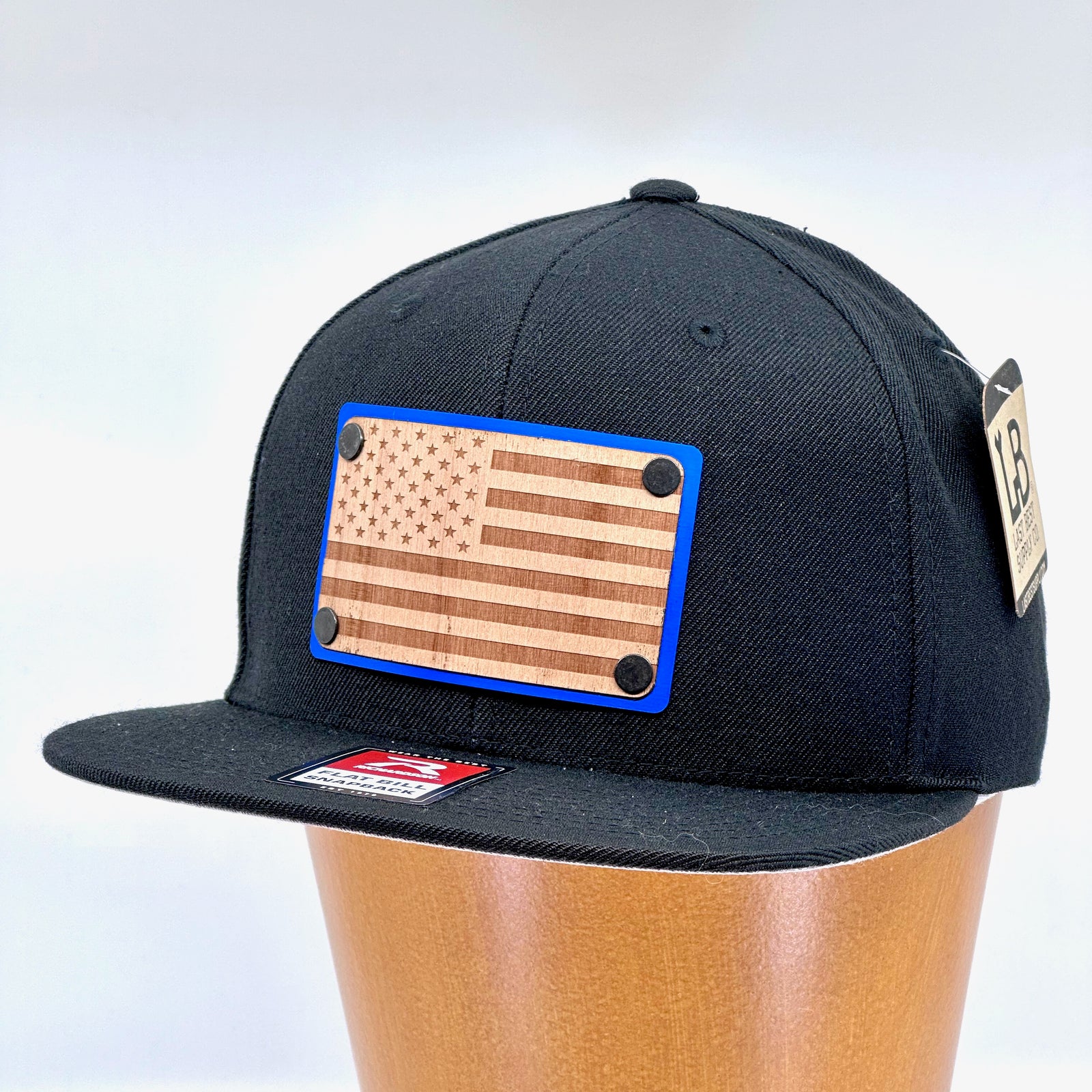 American Flag Wood & Blue Anodized Aluminum Plate Richardson Flat Bill Hat featuring an American Flag etched on alder wood veneer and laminated to a blue anodized aluminum plate—handmade in Montana, USA by Last Best Supply Co.