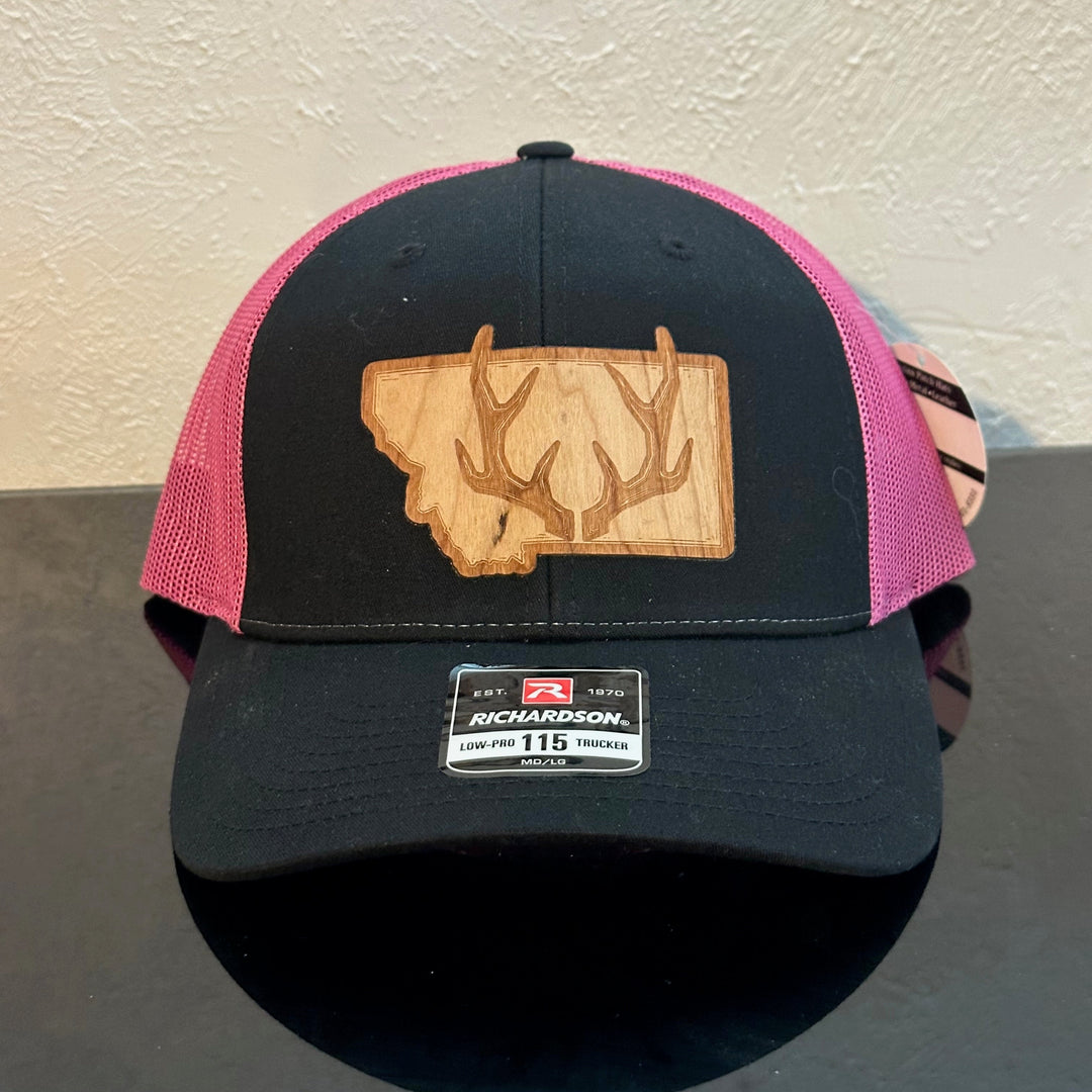 Front of a Richardson 115 Black & Pink trucker hat decorated with a Montana Antler Cherry Wood Patch - a pair of deer antlers superimposed on the state of Montana - made in Montana by Last Best Supply Co.