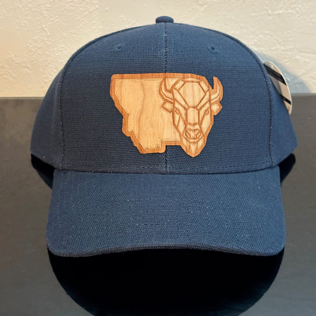 Front of an EConscious Navy Blue Structured Hemp Baseball Hat decorated with a Montana Bison Cherry Wood Patch - a geometric bison head superimposed on the state of Montana - made in Montana by Last Best Supply Co.