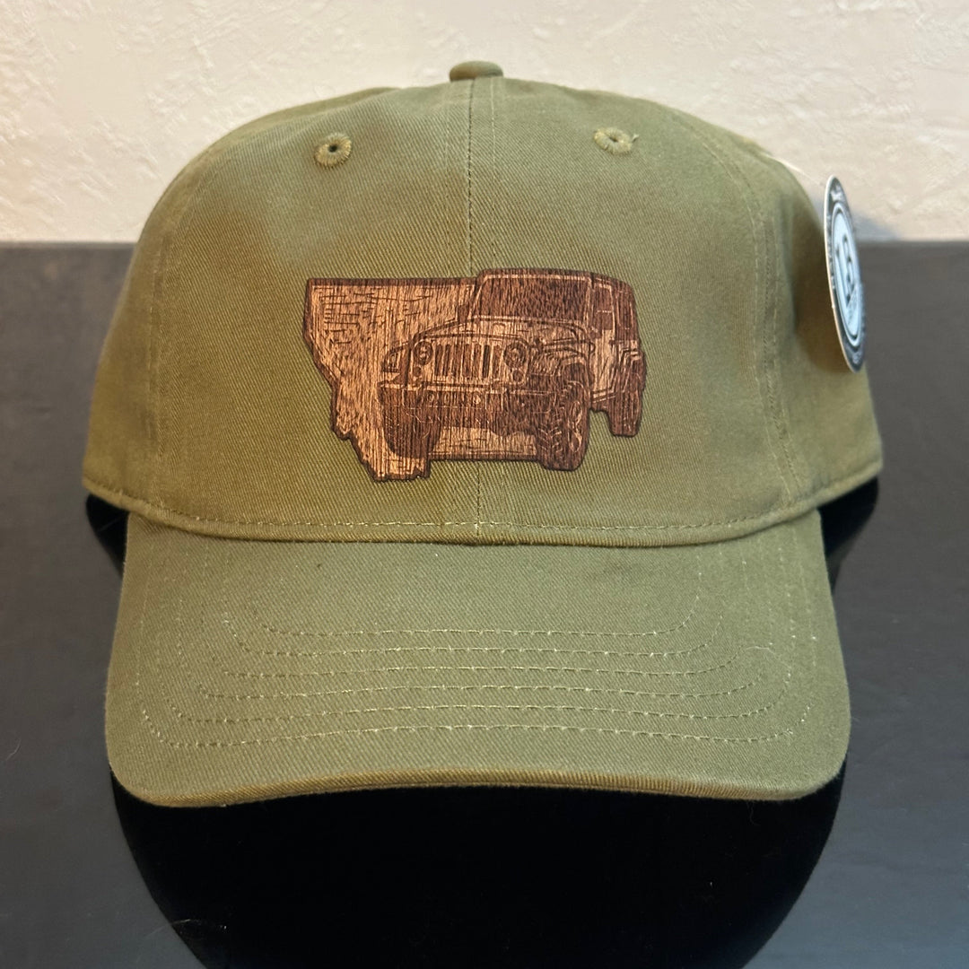 Front of an EConscious Olive 100% Cotton Unstructured Baseball Hat
decorated with a Montana Jeep Mahogany Wood Patch - a sketch of a jeep superimposed on the state of Montana - made in Montana by Last Best Supply Co.