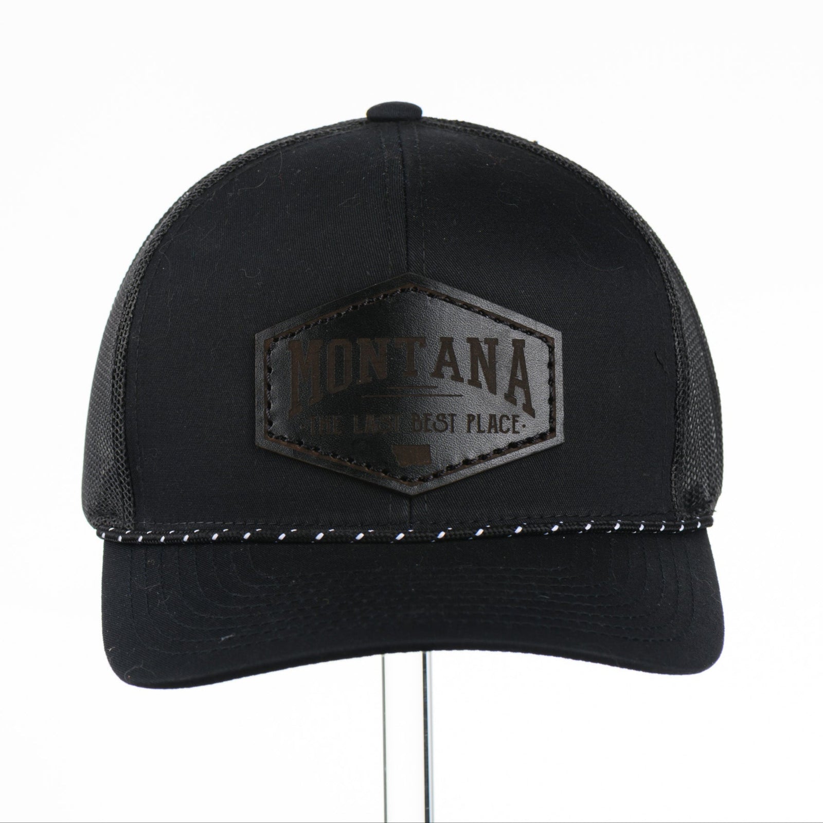 Black trucker cap with Montana The Last Best Place Leather Patch logo on a white background