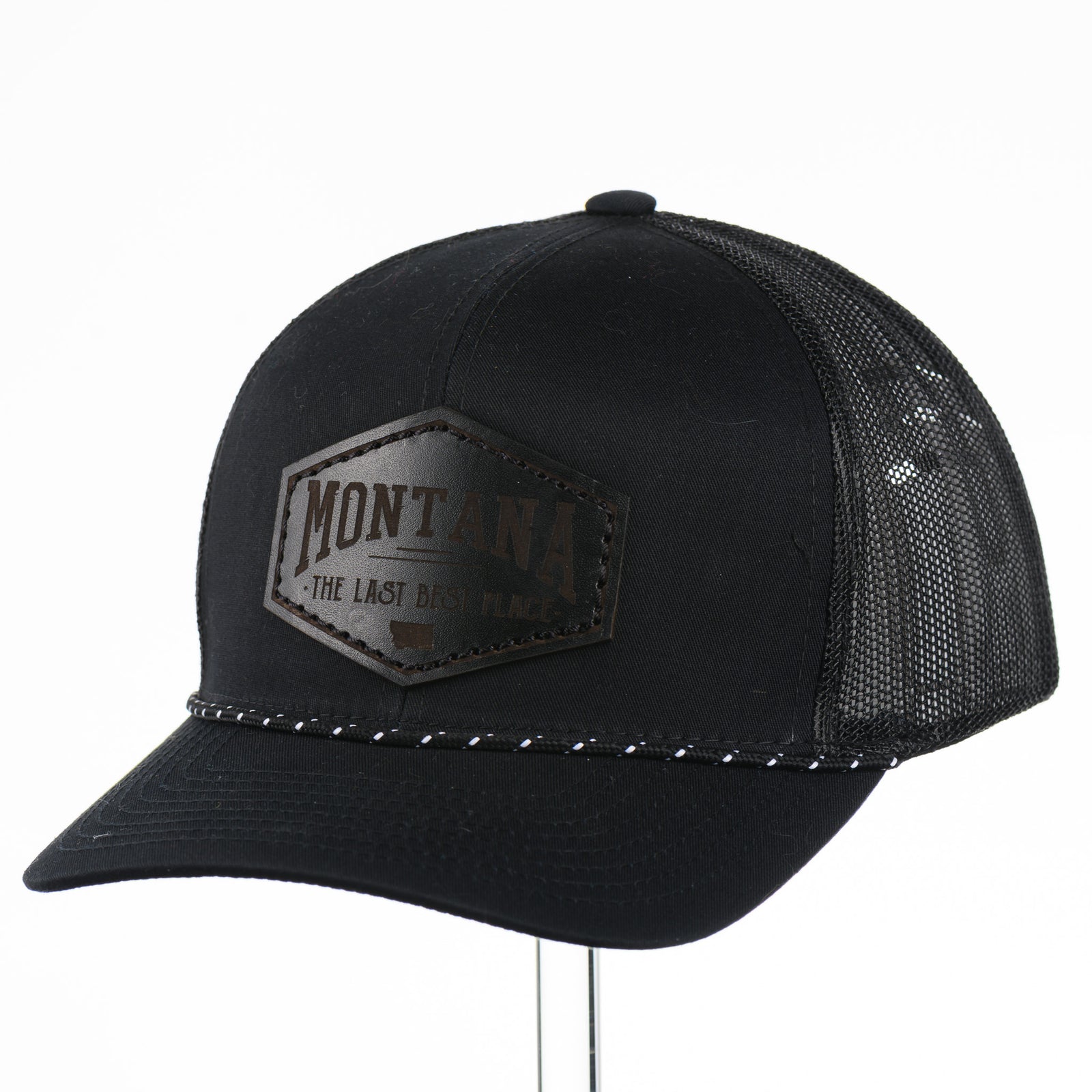 Black trucker cap with 'Montana The Last Best Place' Leather Patch logo on a white background