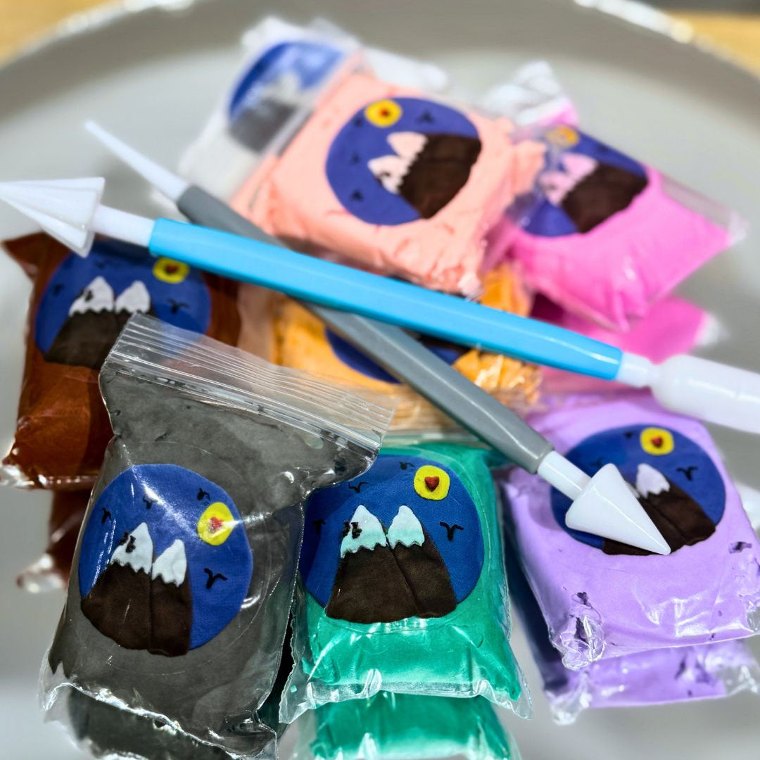 A picture of the clay tools and little bags of colorful clay with a mountain image on them