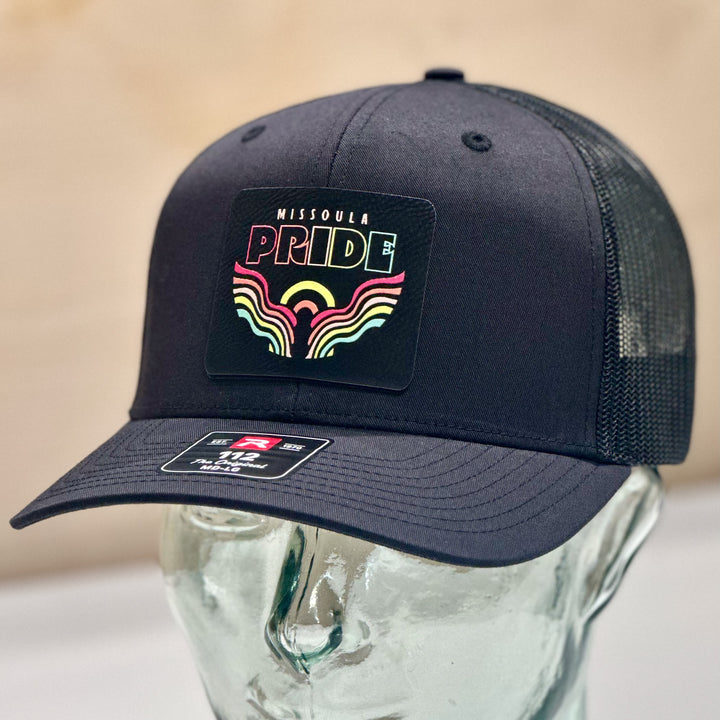 A black richardson 112 trucker hat with a 2026 Missoula Pride Portal leatherette patch