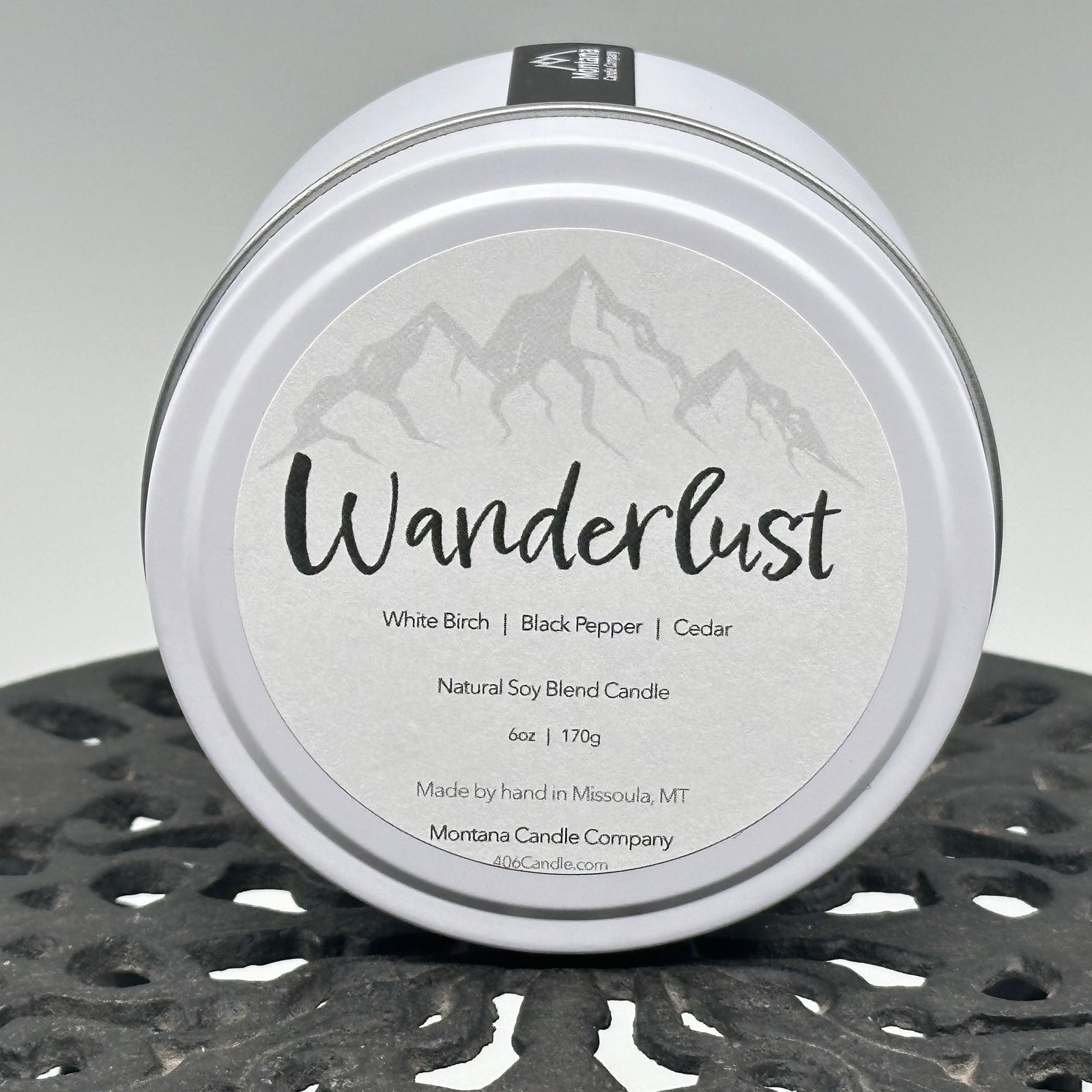 Wanderlust Candle soy blend candle handmade in Missoula, Montana by Montana Candle Company, scented with a white birch, black pepper, and cedar, 6 oz. tin