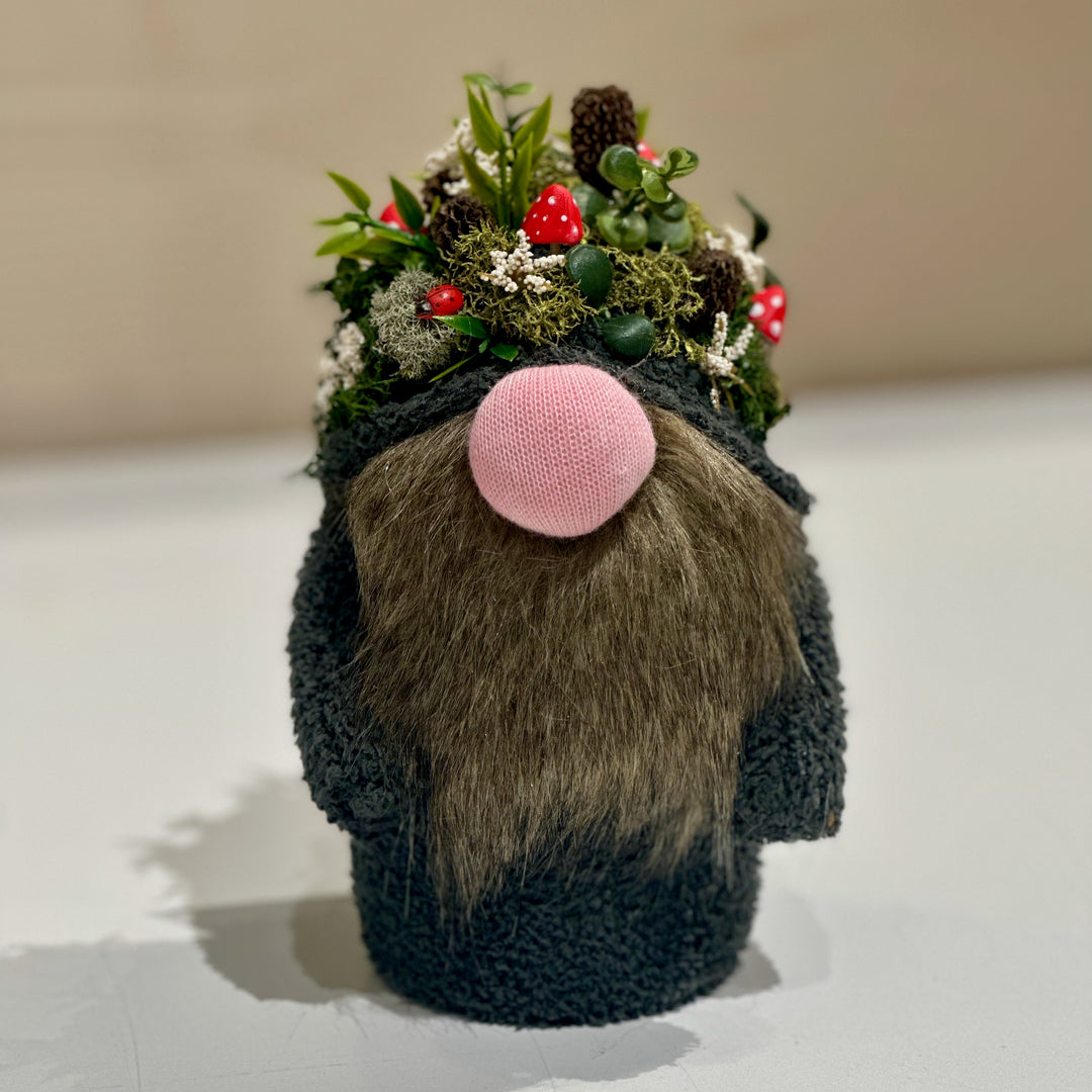 A handmade gnome with a hat made of mushrooms and forest goodies