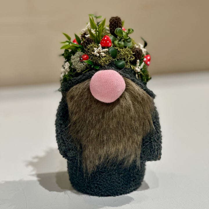 A handmade gnome with a hat made of mushrooms and forest goodies