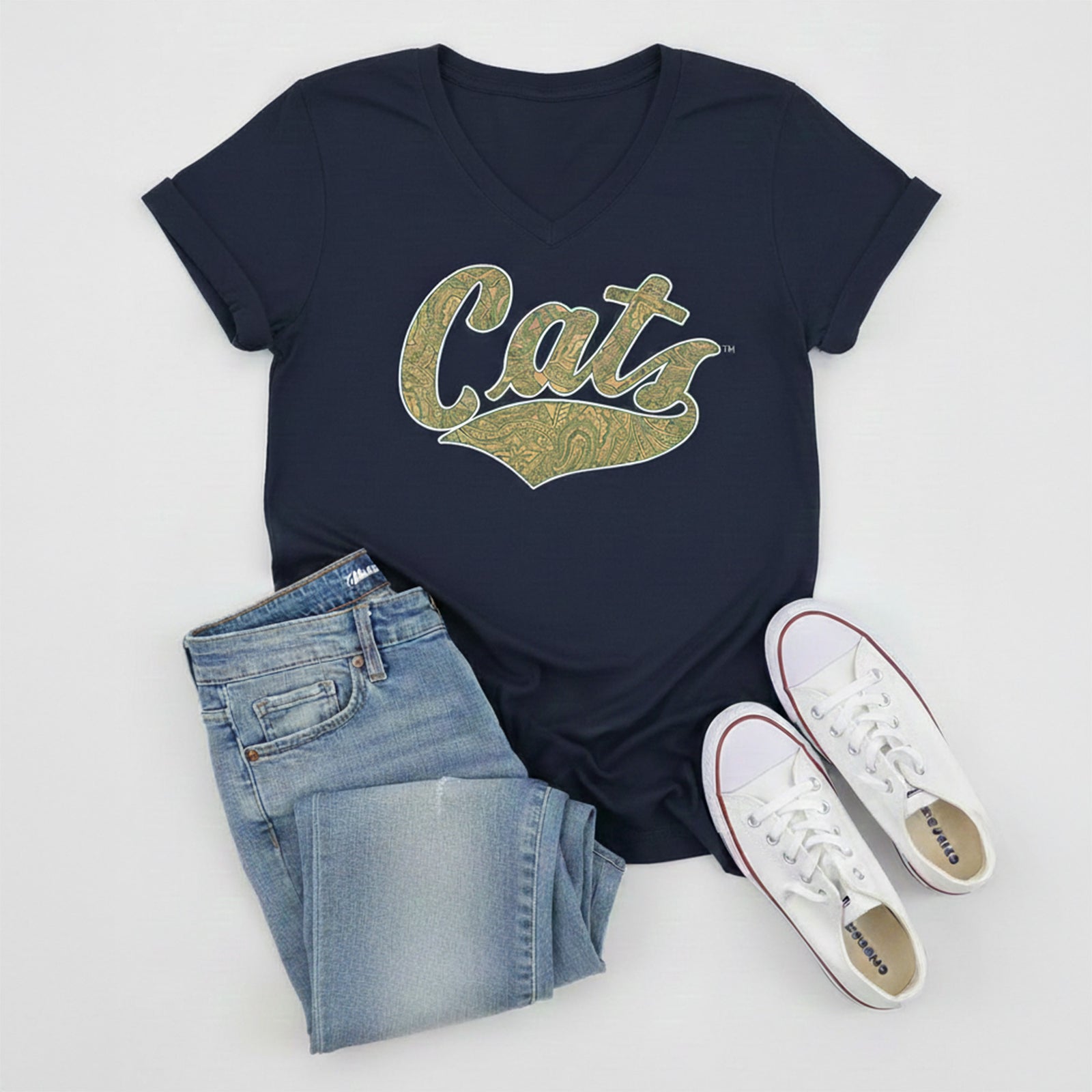 Navy t-shirt with 'Cats' print, blue jeans, and white sneakers on a light gray background