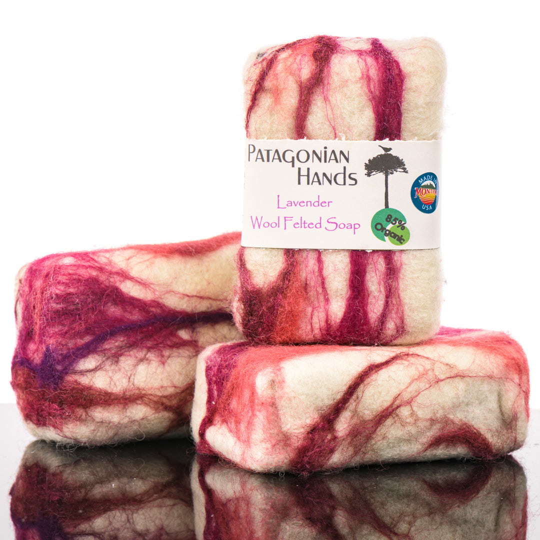 Three bars of Patagonian Hands Lavender wool felted soap with a visible Made in Montana label on a reflective surface.