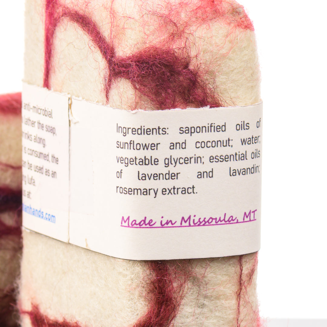 Bar of felted soap with a label detailing ingredients and origin, on a white background. Made in Missoula Montana