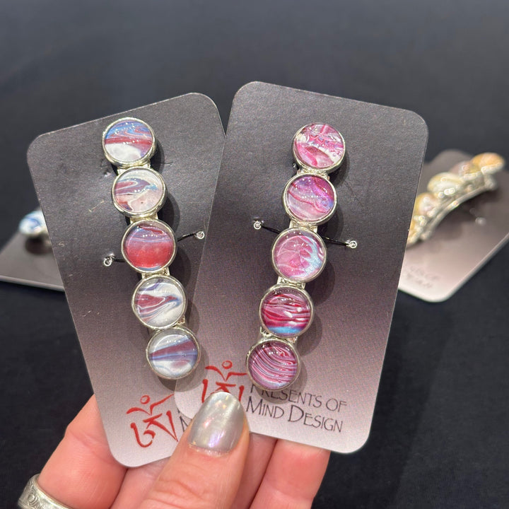 Two stainless steel barrettes made in Montana with purple, red and white paint swirls and hints of blue.