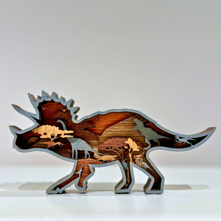 Multiple layers of natural wood are precision laser-cut and hand-assembled to form a dynamic Triceratops silhouette, revealing intricate prehistoric scenes and silhouettes hidden within every tier. Mounted on a sturdy display base, this freestanding wooden sculpture