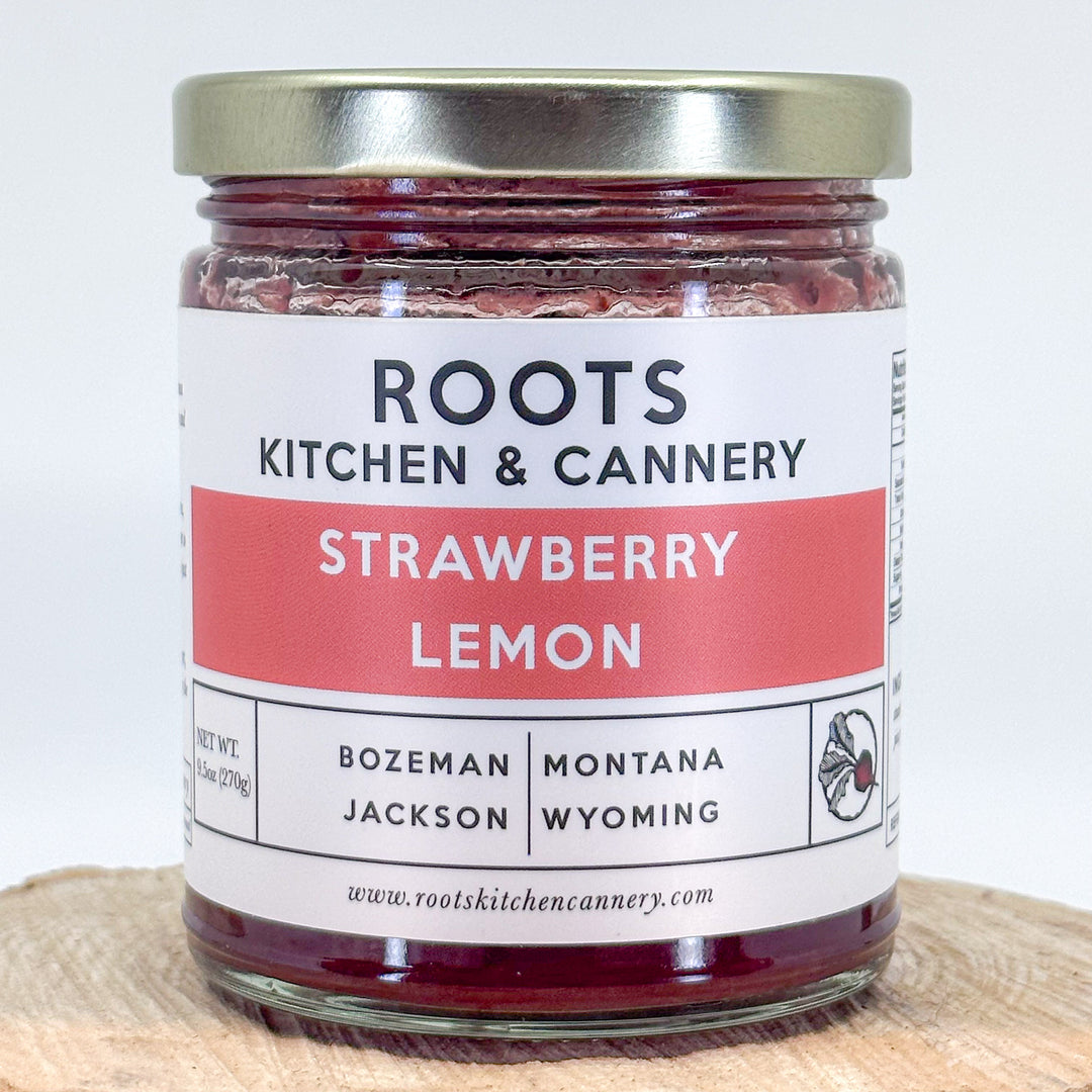 The front of a jar of strawberry lemon jam made by Roots Kitchen & cannery in Bozeman, MT. The label is modern and clean looking.