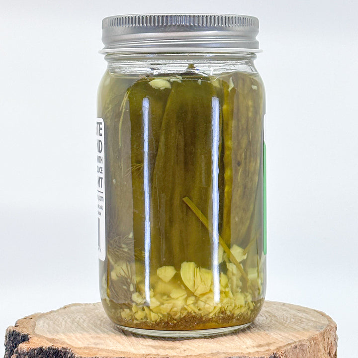 The back of a jar of pickles, showing the pickles in their brine with dill and garlic chunks