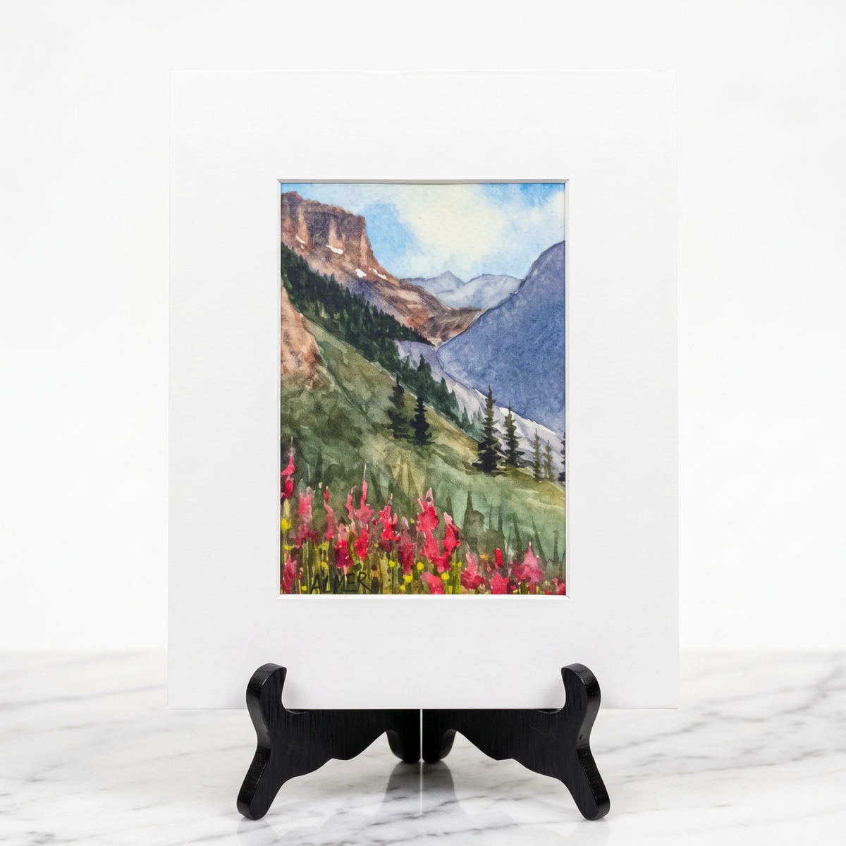 Capture Montana’s mountain beauty with the Fireweed Valley Matted Print by Stark Mountain Studio, featuring Bobbe Almer’s watercolor wildflower art.