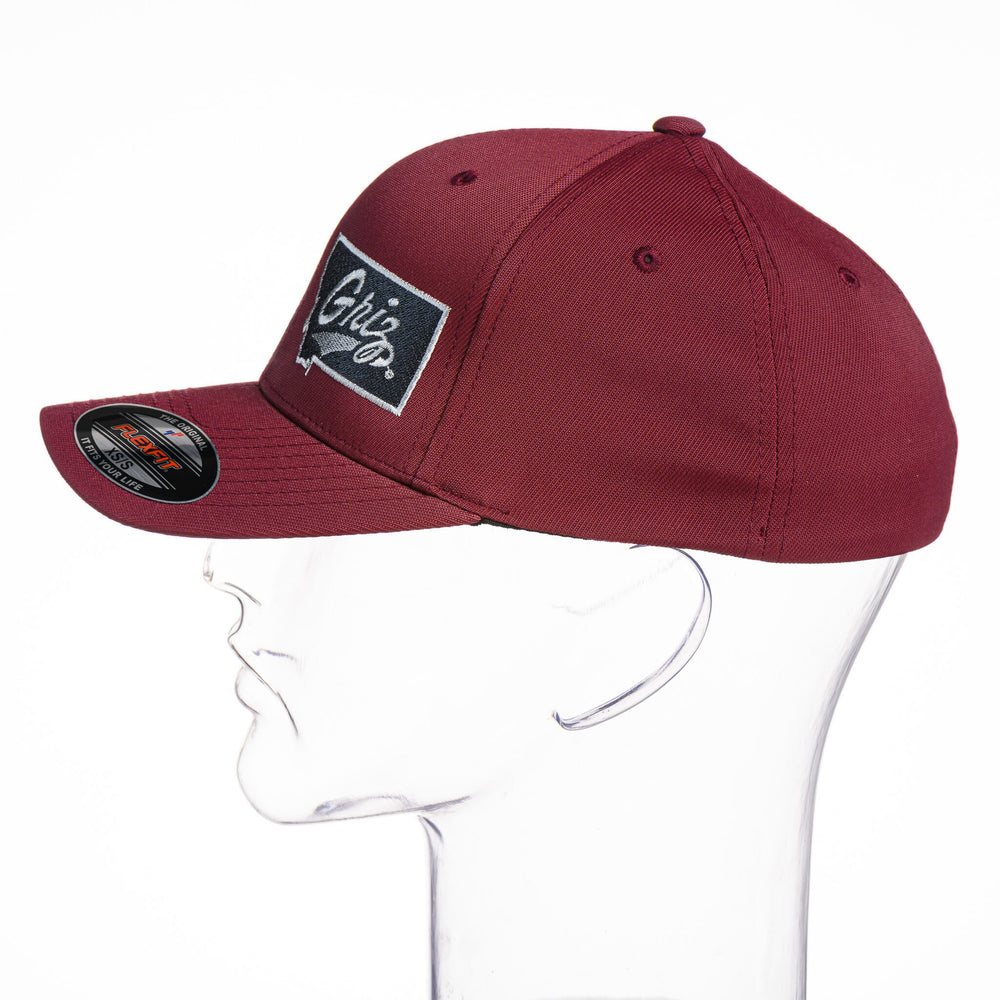 Blue Peaks Creative's maroon Performance Solid Cap embroidered with the Montana Griz Script in black and silver, side
