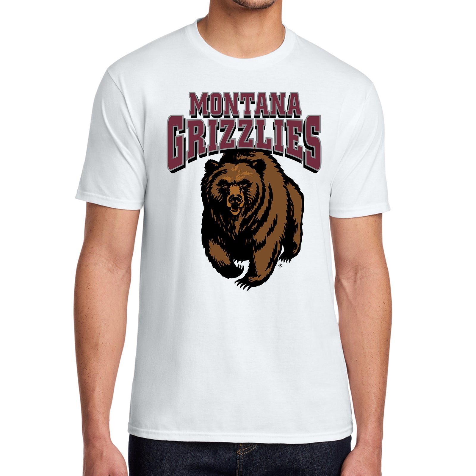A white short-sleeve crewneck t-shirt featuring a graphic of a charging grizzly bear and the text 'MONTANA GRIZZLIES' in maroon and white, modeled on a person against a plain white background.