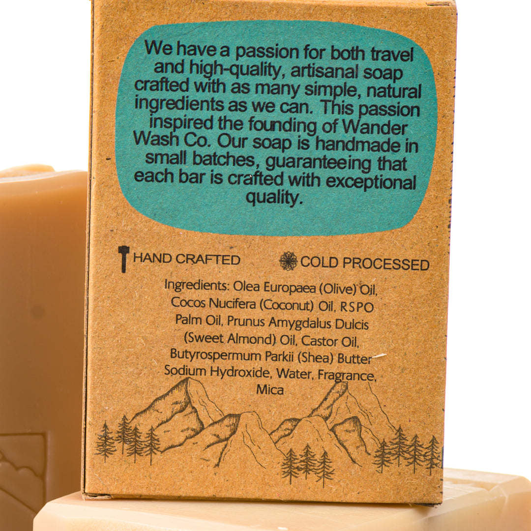 Display of three 5.25 oz bars of Beachside In Bali Bar Soap, Natural Cold Process Soap (with shea butter)—one in the box and two out of the box--made in Montana by Wander Wash Co, focused on back (ingredients list) against a white background