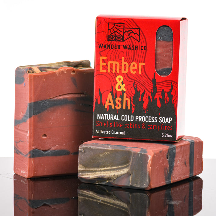Display of three 5.25 oz bars of Ember &amp; Ash Bar Soap, Natural Cold Process Soap (wood, amber, sandalwood)—one in the box and two out of the box--made in Montana by Wander Wash Co, against a white background