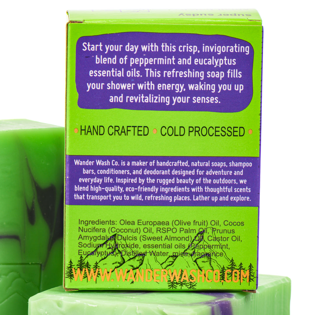 Display of three 5.25 oz bars of Panda Breath Mints Bar Soap, Natural Cold Process Soap (eucalyptus, mint)—one in the box and two out of the box--made in Montana by Wander Wash Co, focused on back (ingredients list) against a white background