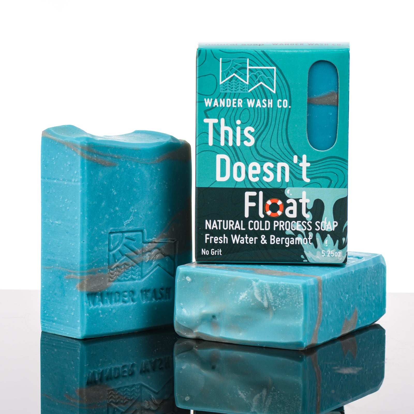 Display of three 5.25 oz bars of This Doesn’t Float, Natural Cold Process Soap (fresh water, bergamot)--one in the box and two out of the box--made in Montana by Wander Wash Co, against a white background
