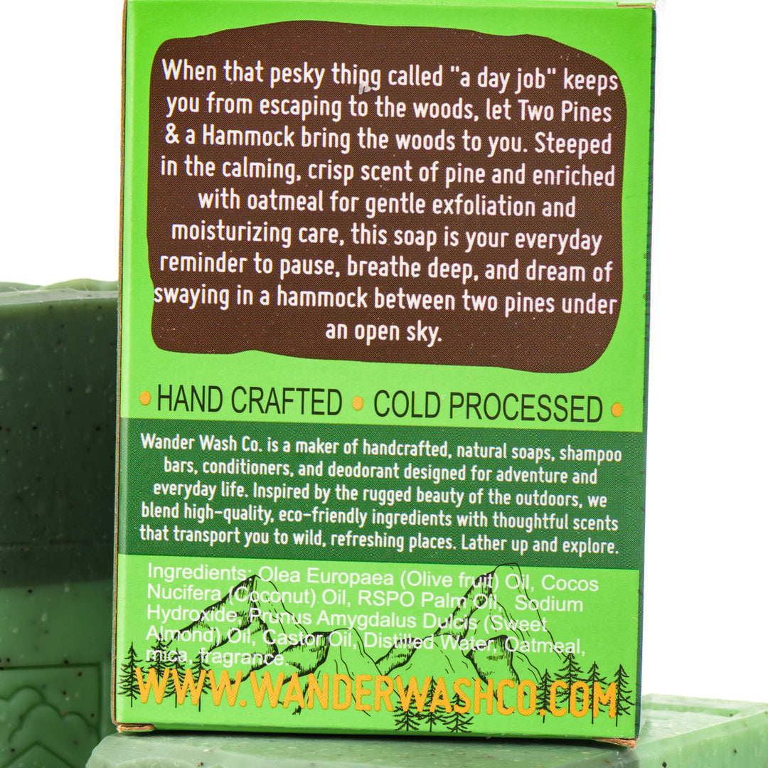 Display of three 5.25 oz bars of Two Pines &amp; A Hammock Bar Soap, Natural Cold Process Soap (pine, oatmeal)—one in the box and two out of the box--made in Montana by Wander Wash Co, focused on back (ingredients list) against a white background
