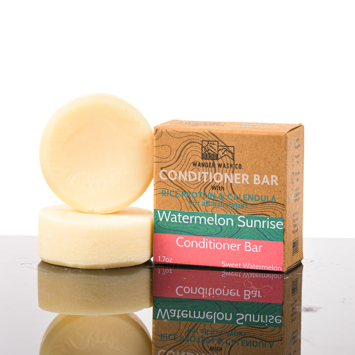 Display of three 1.7 oz bars of Watermelon Sunrise Conditioner Bar (sweet watermelon)—one in the box and two out of the box--made in Montana by Wander Wash Co, against a white background