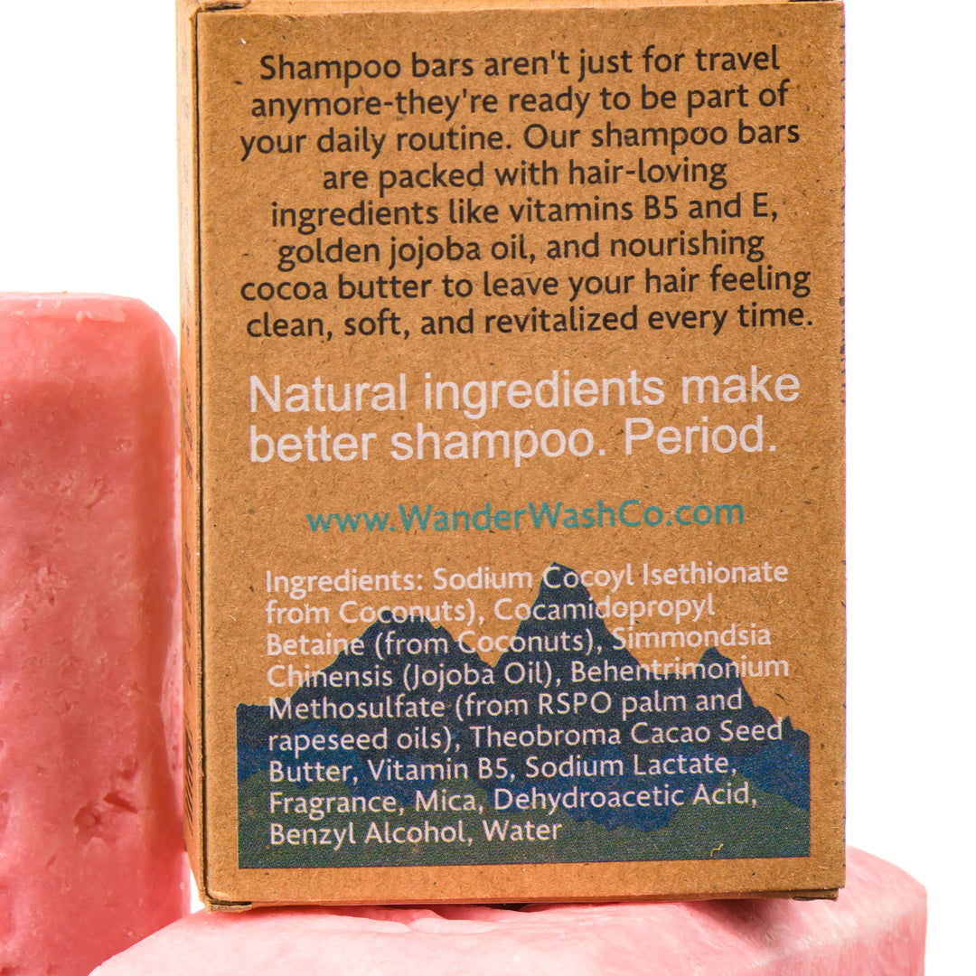 Display of three 4.5 oz bars of Watermelon Sunrise Shampoo Bar (sweet watermelon)—one in the box and two out of the box--made in Montana by Wander Wash Co, focused on back (ingredients list) against a white background