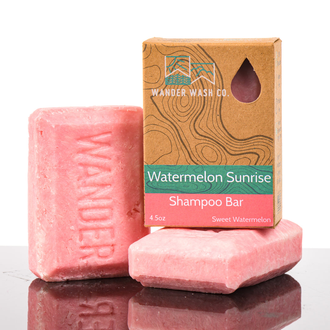 Display of three 4.5 oz bars of Watermelon Sunrise Shampoo Bar (sweet watermelon)—one in the box and two out of the box--made in Montana by Wander Wash Co, against a white background