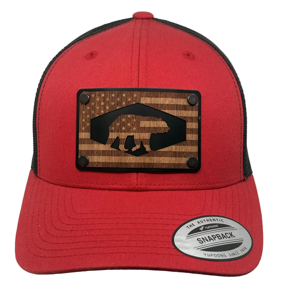 Red snapback cap with wooden patch featuring American flag Bear design on a white background
